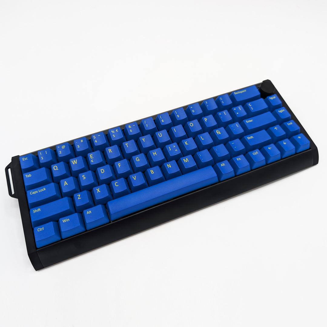 Blue OEM profile QWERTY PBT keycaps installed on a mechanical keyboard, showing non-backlit keys with dye-sublimated yellow legends