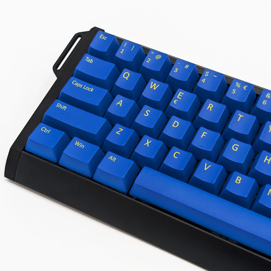 Close-up of blue QWERTY PBT keycaps with yellow legends, non-backlit OEM profile keys with a matte finish on a mechanical keyboard.