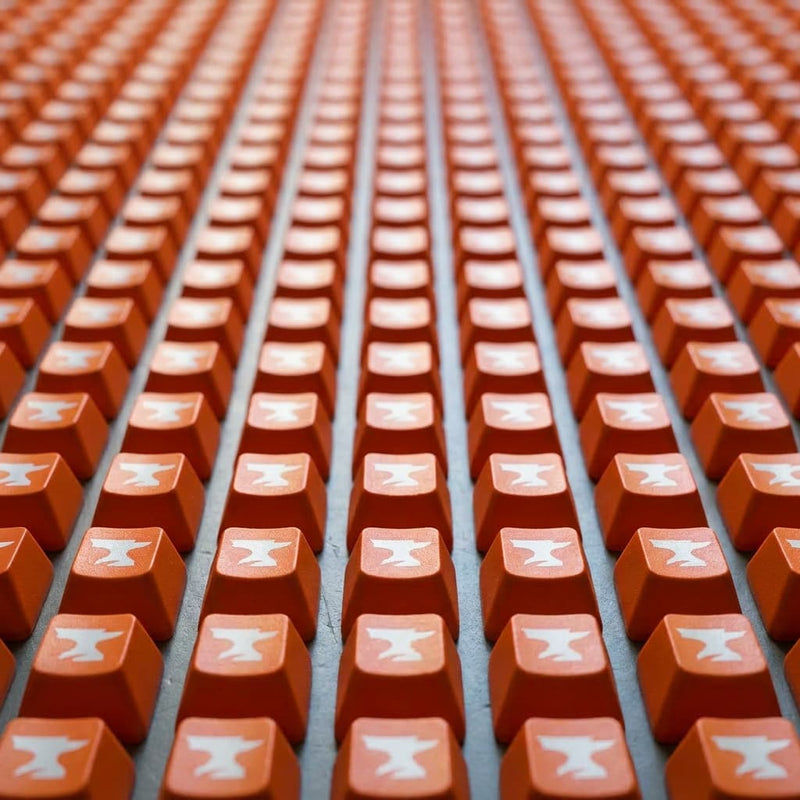 Close-up of orange keycaps with white symbols arranged in rows.