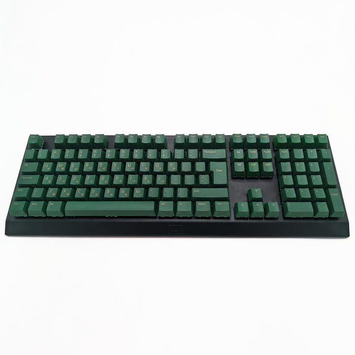 Customisable green non-backlit QWERTY PBT keycaps with gold legends on a mechanical keyboard, featuring OEM profile keys.