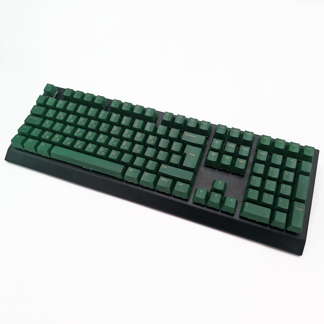 Green OEM profile QWERTY PBT keycaps installed on a mechanical keyboard, showing non-backlit keys with dye-sublimated gold legends.