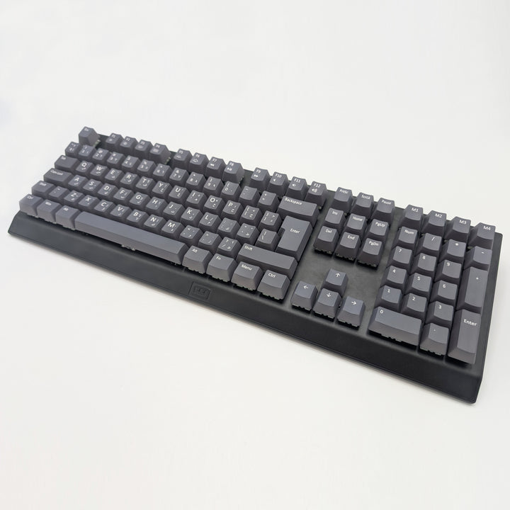 Grey OEM profile QWERTY PBT keycaps installed on a mechanical keyboard, showing non-backlit keys with dye-sublimated white legends.