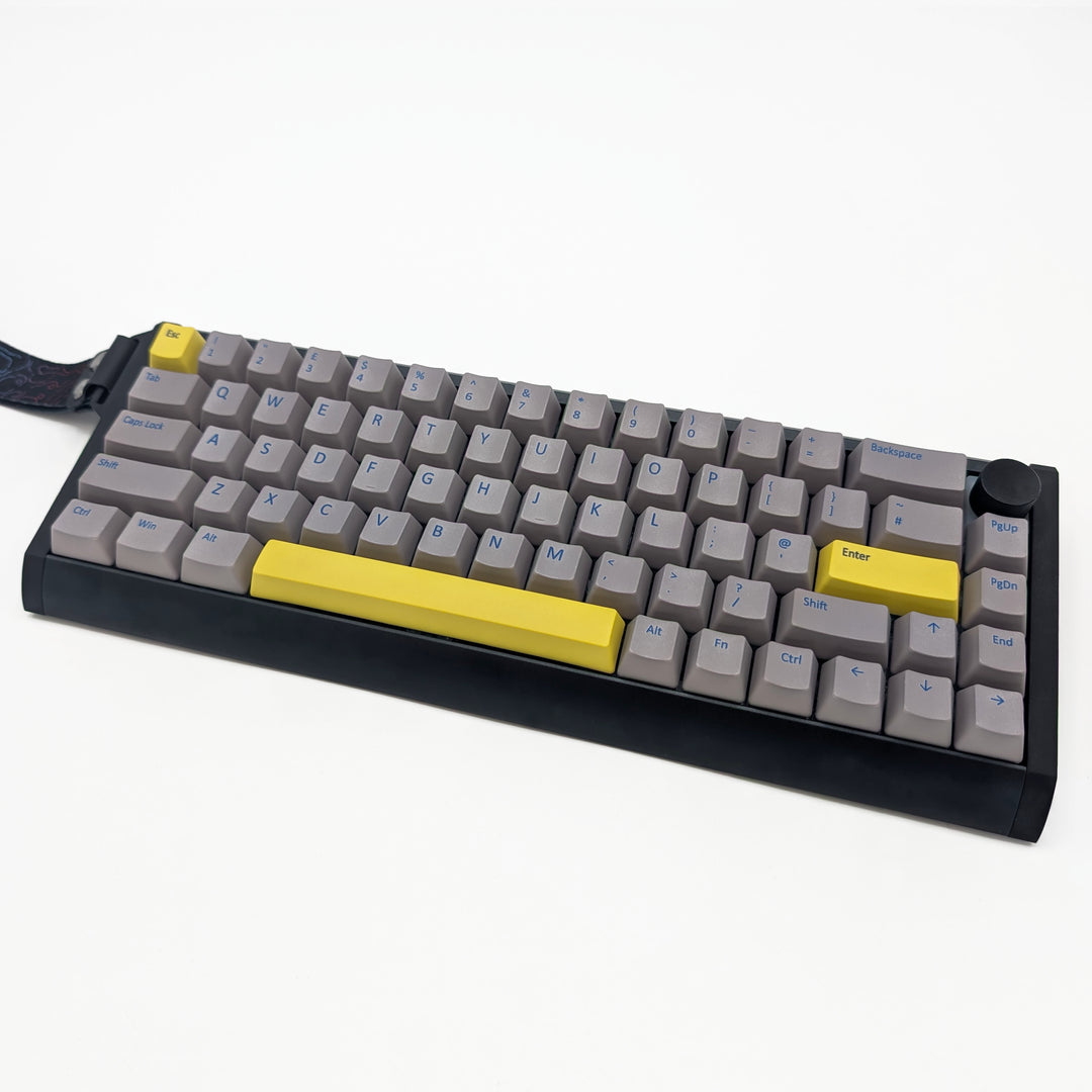 Light grey OEM profile QWERTY PBT keycaps installed on a mechanical keyboard, showing non-backlit keys with dye-sublimated blue legends.