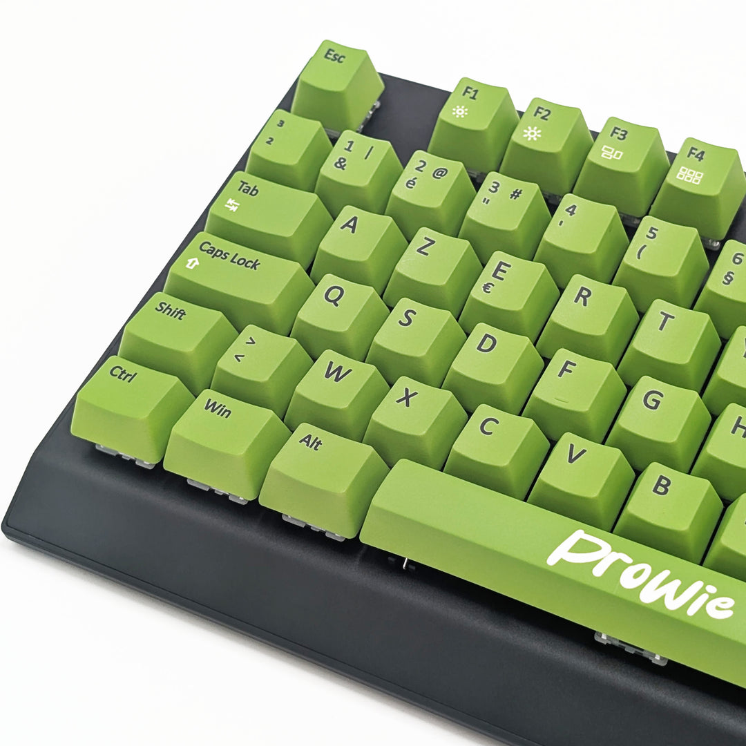 Close-up of light green AZERTY PBT keycaps with black legends, non-backlit OEM profile keys with a matte finish on a mechanical keyboard.