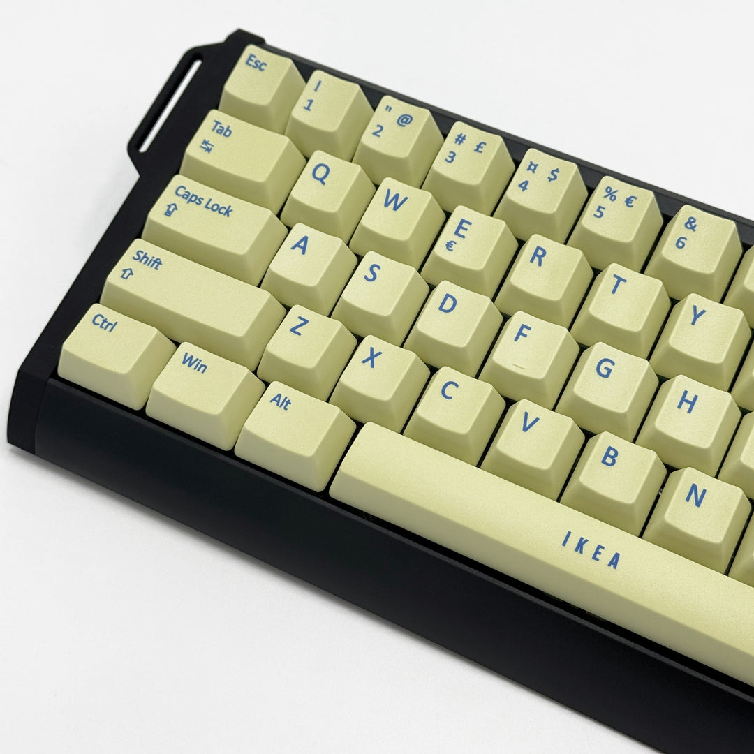Close-up of Light Yellow QWERTY PBT keycaps with blue legends, non-backlit OEM profile keys with a matte finish on a mechanical keyboard.