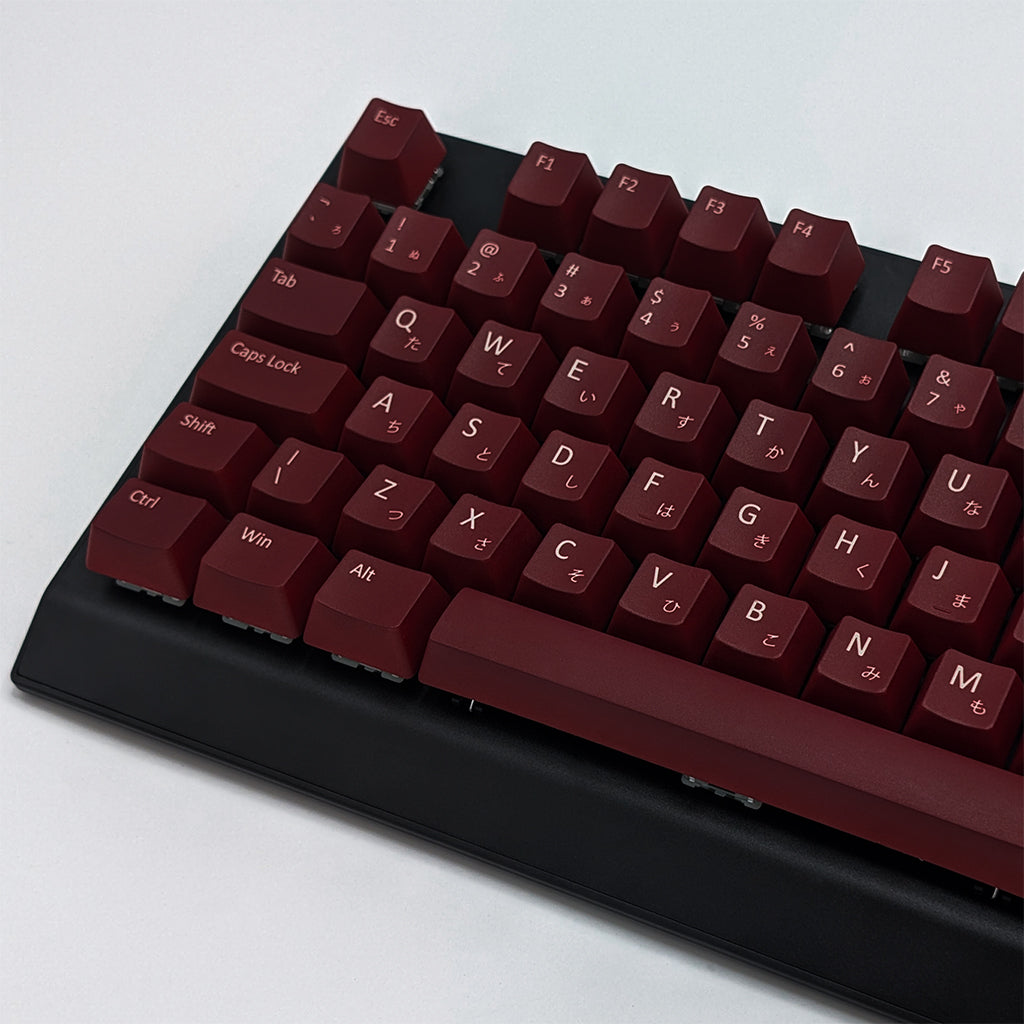 Close-up of Maroon QWERTY PBT keycaps with white legends, non-backlit ISO-compatible OEM profile keys with matte finish on a mechanical keyboard.