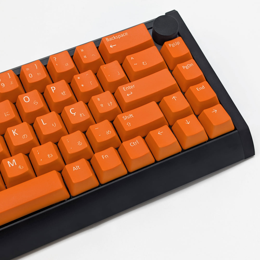 Mechanical keyboard fitted with customisable Orange QWERTY PBT keycaps, non-backlit ANSI OEM profile with white legends and matte finish.