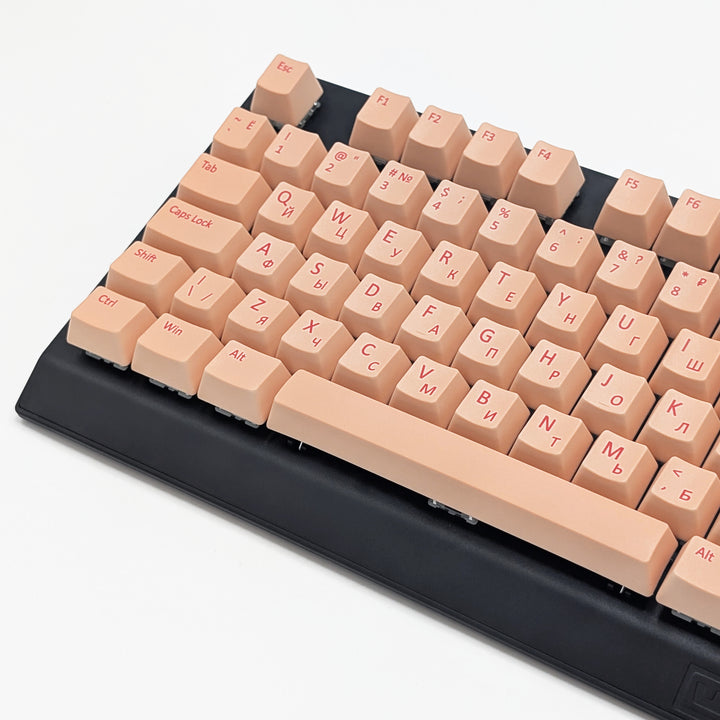 Close-up of Peach QWERTY PBT keycaps with cherry red legends, non-backlit ISO-compatible OEM profile keys with matte finish on a mechanical keyboard.