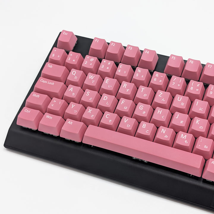 Close-up of Pink QWERTZ PBT keycaps with white legends, non-backlit ISO-compatible OEM profile keys with matte finish on a mechanical keyboard.