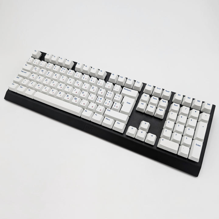 White ISO-compatible QWERTY OEM profile PBT keycaps with matte finish installed on a mechanical keyboard, showing non-backlit keys with dye-sublimated blue and red legends.