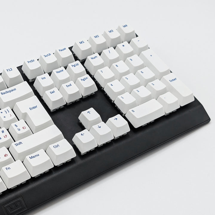 Mechanical keyboard fitted with customisable white PBT keycaps, non-backlit ISO-compatible QWERTY OEM profile with blue and red legends and matte finish.