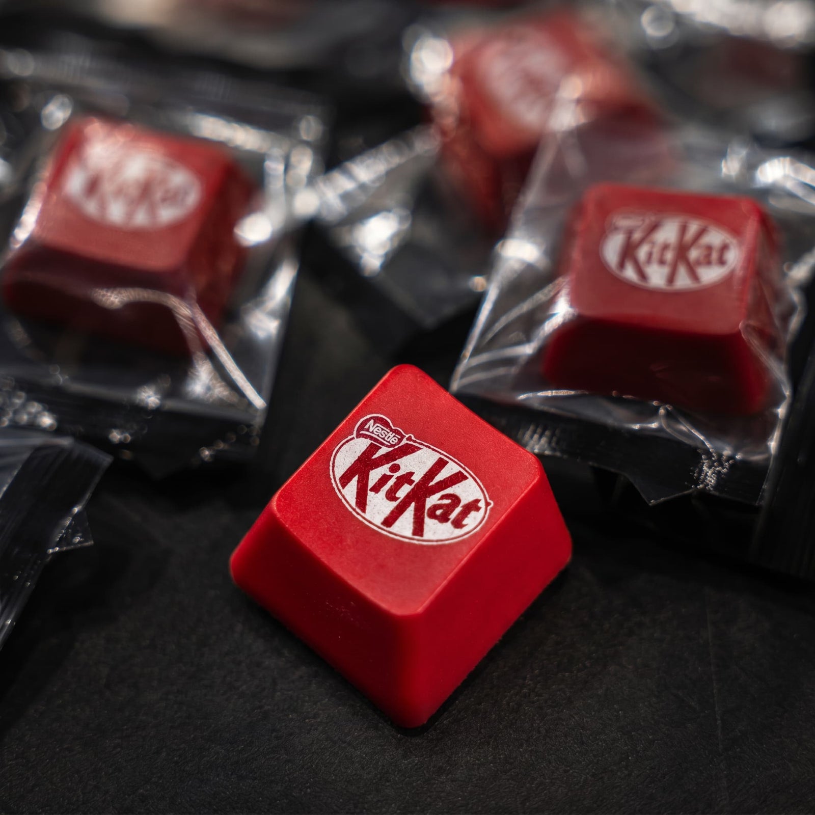 Red KitKat keyboard keypcas in clear packaging on a dark surface
